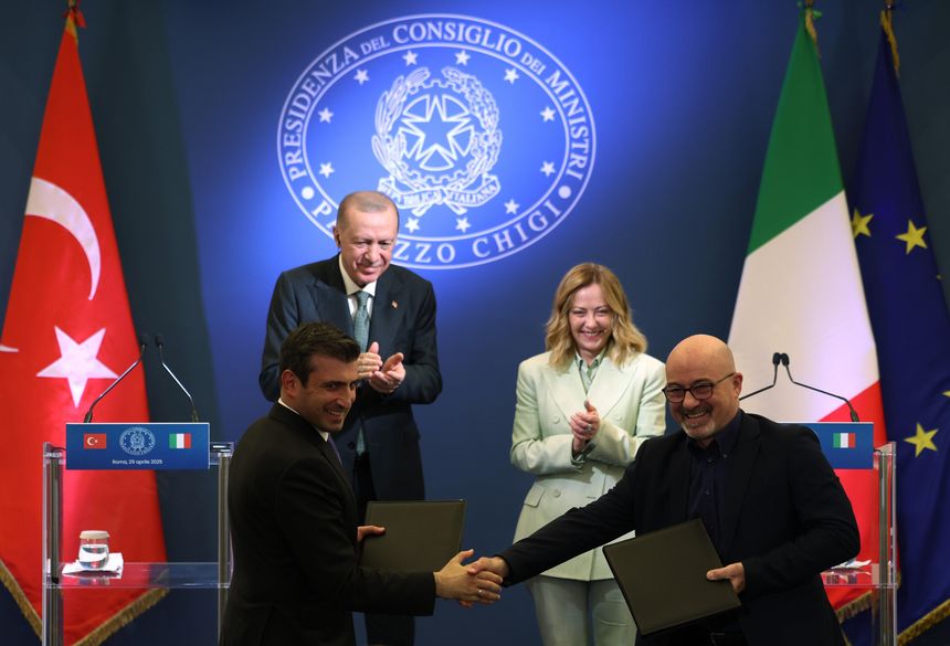 Two men shake hands.