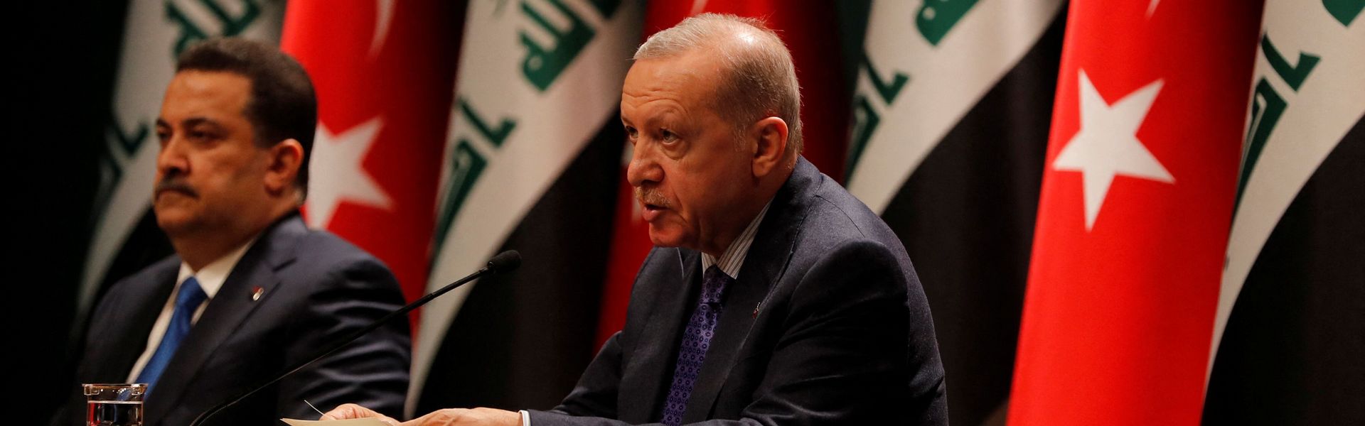 Turkish President Recep Tayyip Erdogan and Iraqi Prime Minister Mohammed Shia al-Sudani sit next to each other