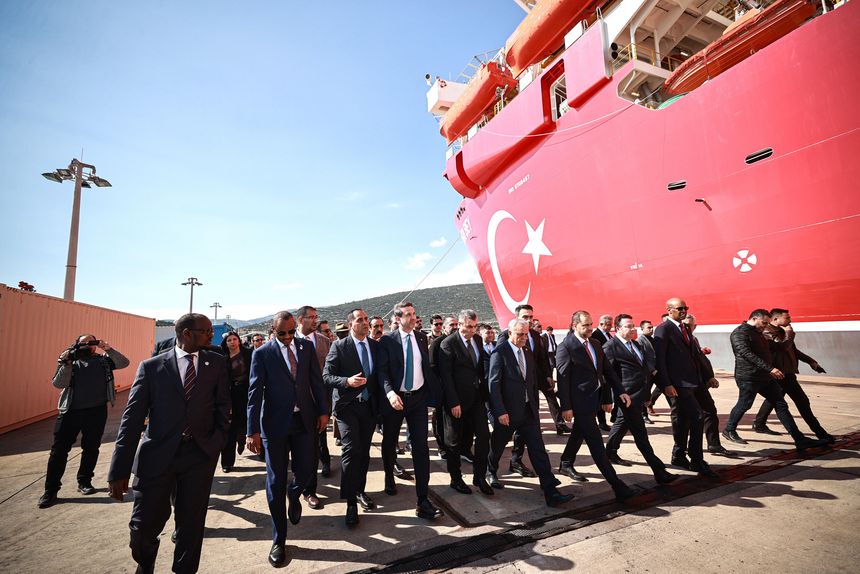 Menschengruppe vor einem Schiff am Hafen