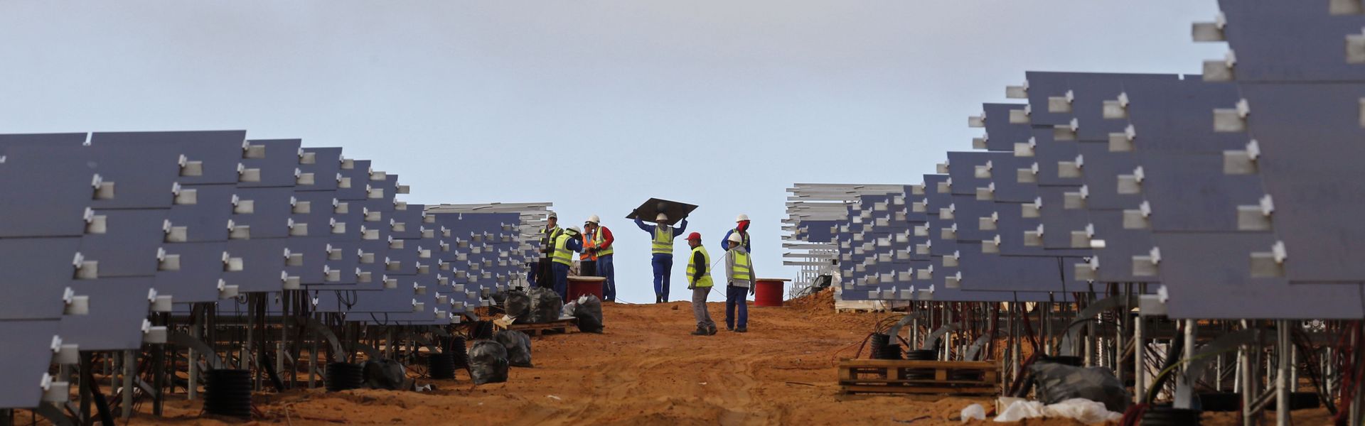Workers install solar panels at a photovoltaic solar farm in Lamberts Bay, South Africa. Italy's TerniEnergia launched the solar park, expected to produce up to 75 megawatts for South Africa's power grid.