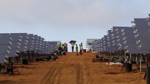 Workers install solar panels at a photovoltaic solar farm in Lamberts Bay, South Africa. Italy's TerniEnergia launched the solar park, expected to produce up to 75 megawatts for South Africa's power grid.