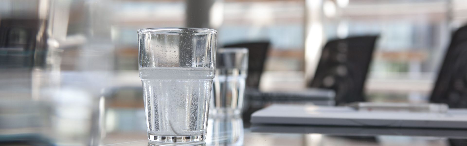 Glasses of water on conference room table.